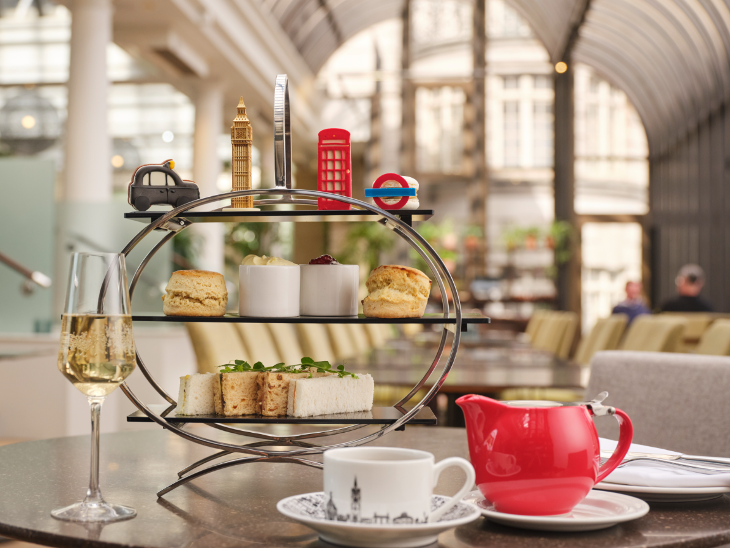Themed afternoon teas London: a three-tiered metal stand filled with sandwiches, scones, and cakes and pastries shaped like London icons